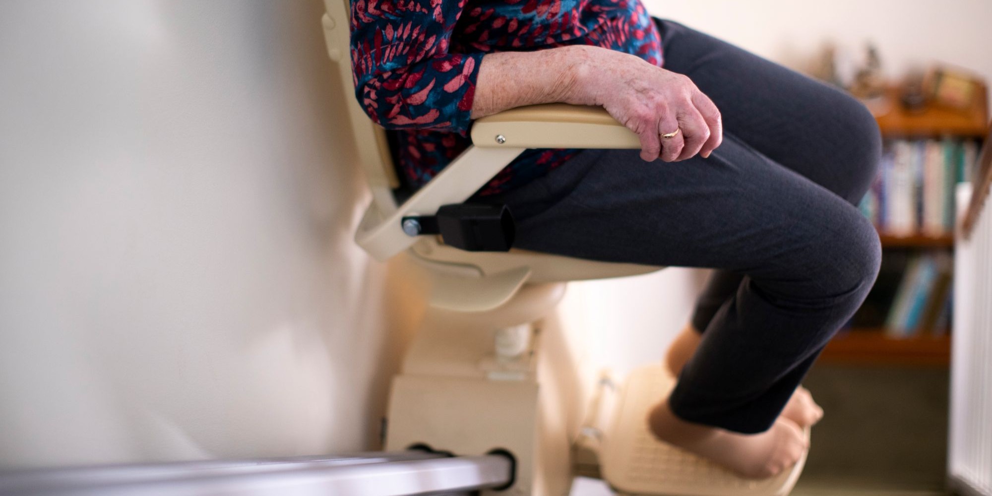 Frau fährt mit Treppenlift