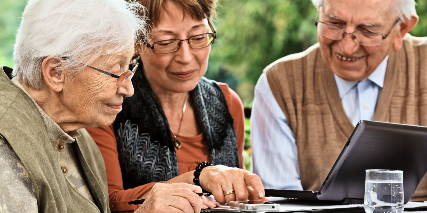 3 ältere Personen sitzen am Tisch
