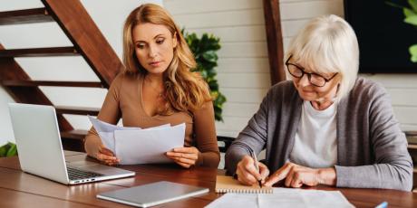 Mutter und Tochter sitzen am Tisch vor einem PC