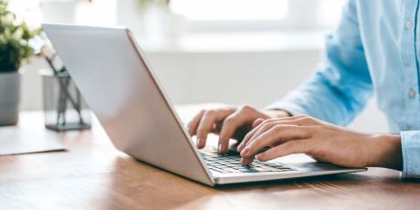 Mann sitzt am Laptop